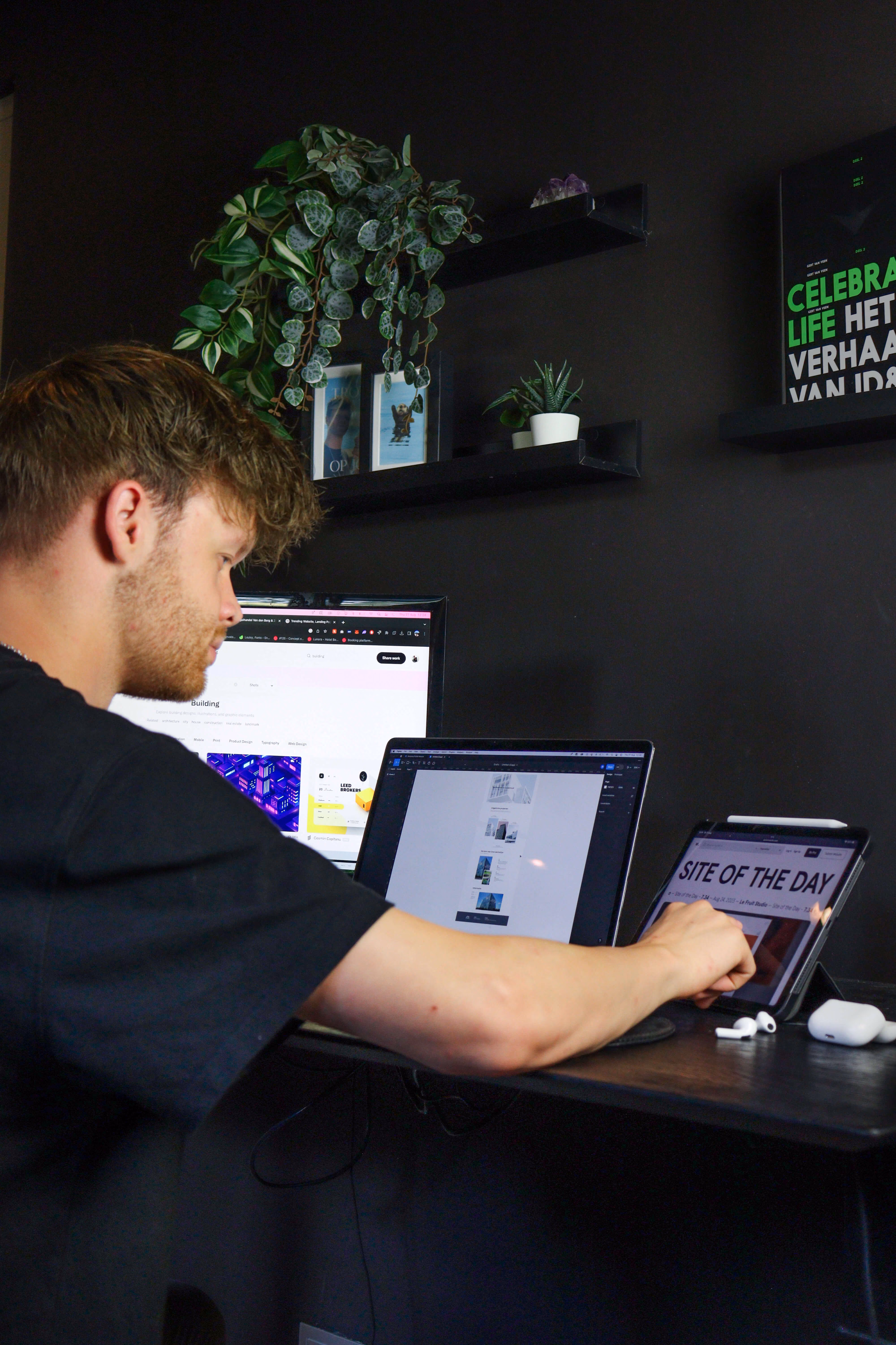 A man looking at screens that have web design on them