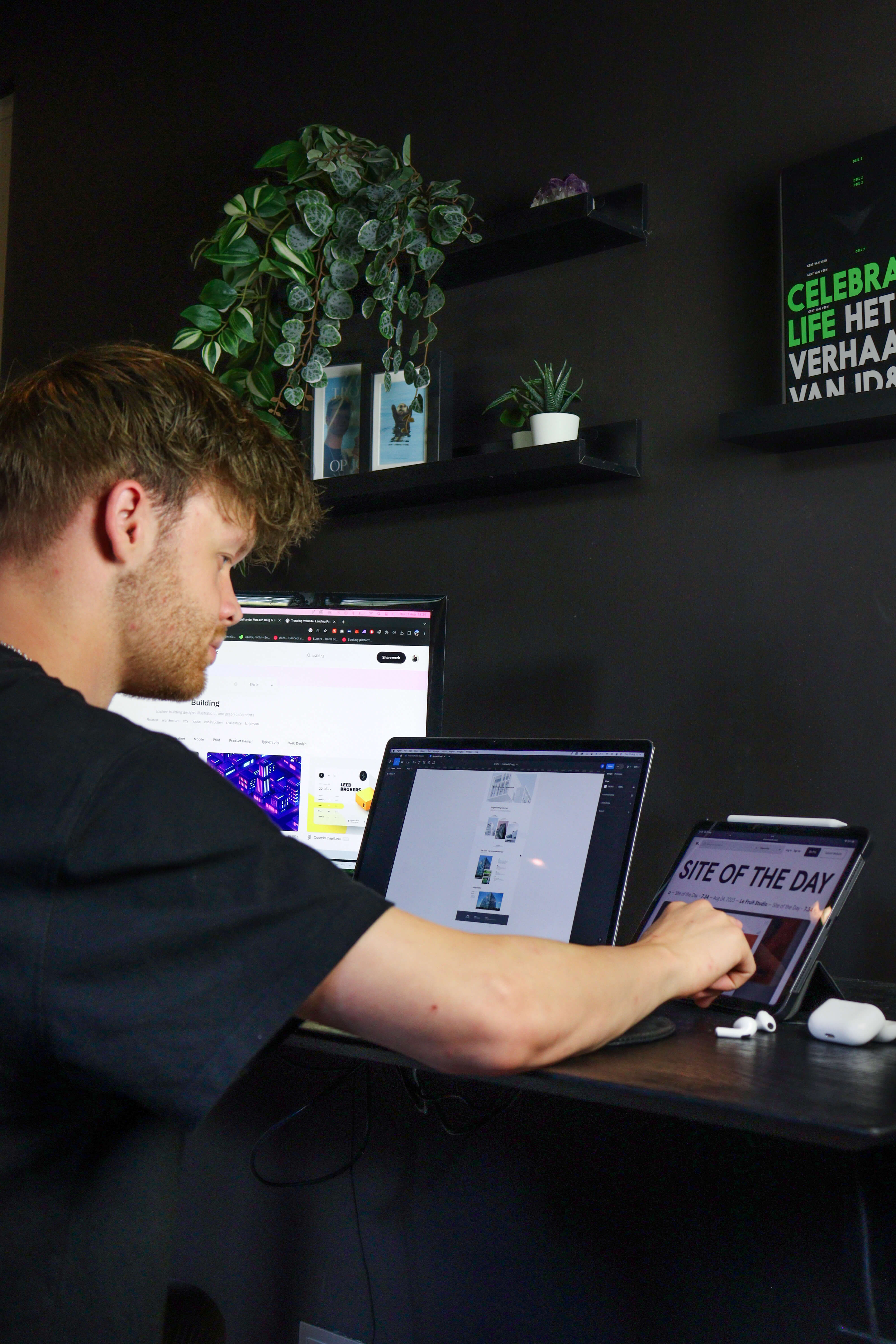 A man looking at screens that have web design on them